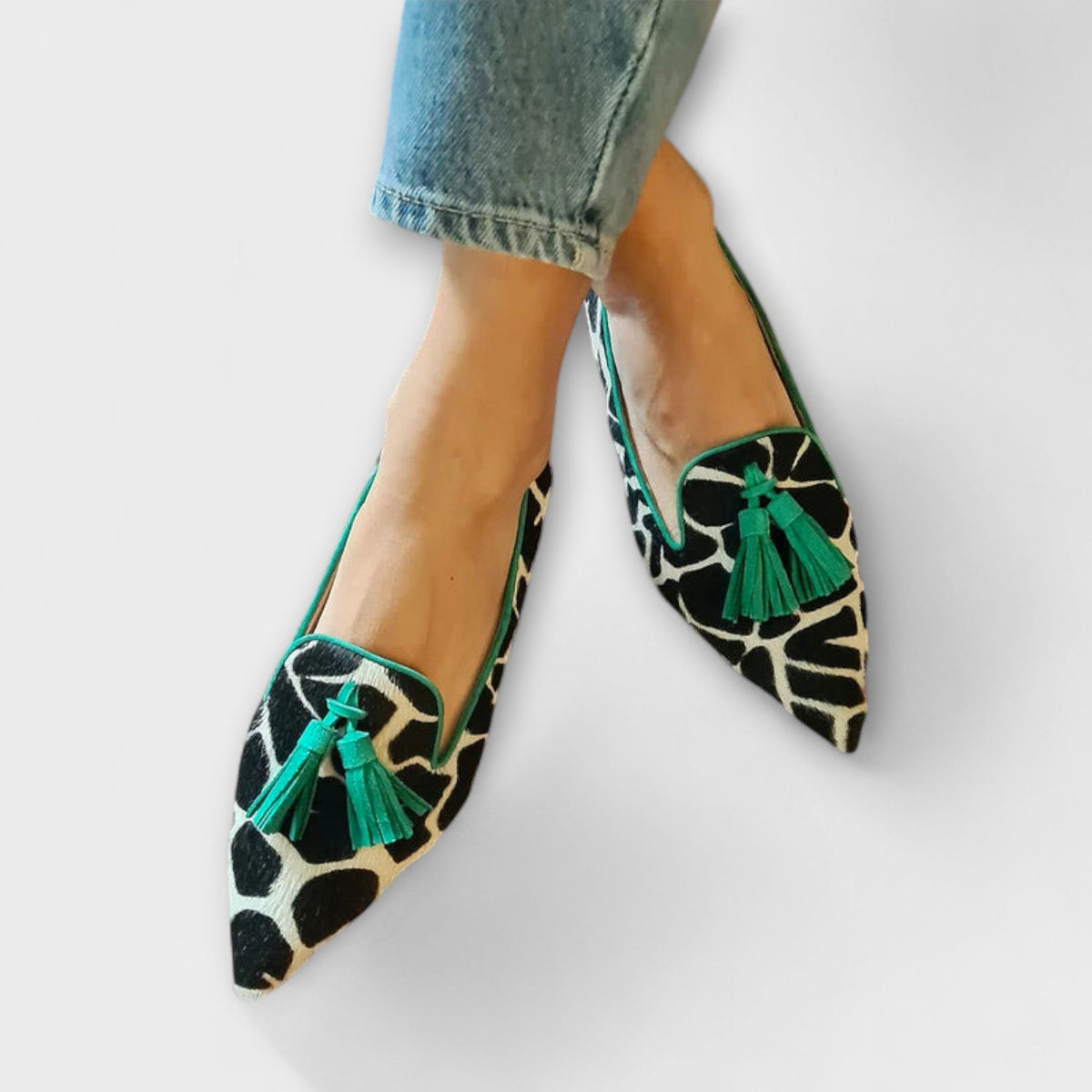 Lucia animal print loafers with green tassels and piping, worn with jeans