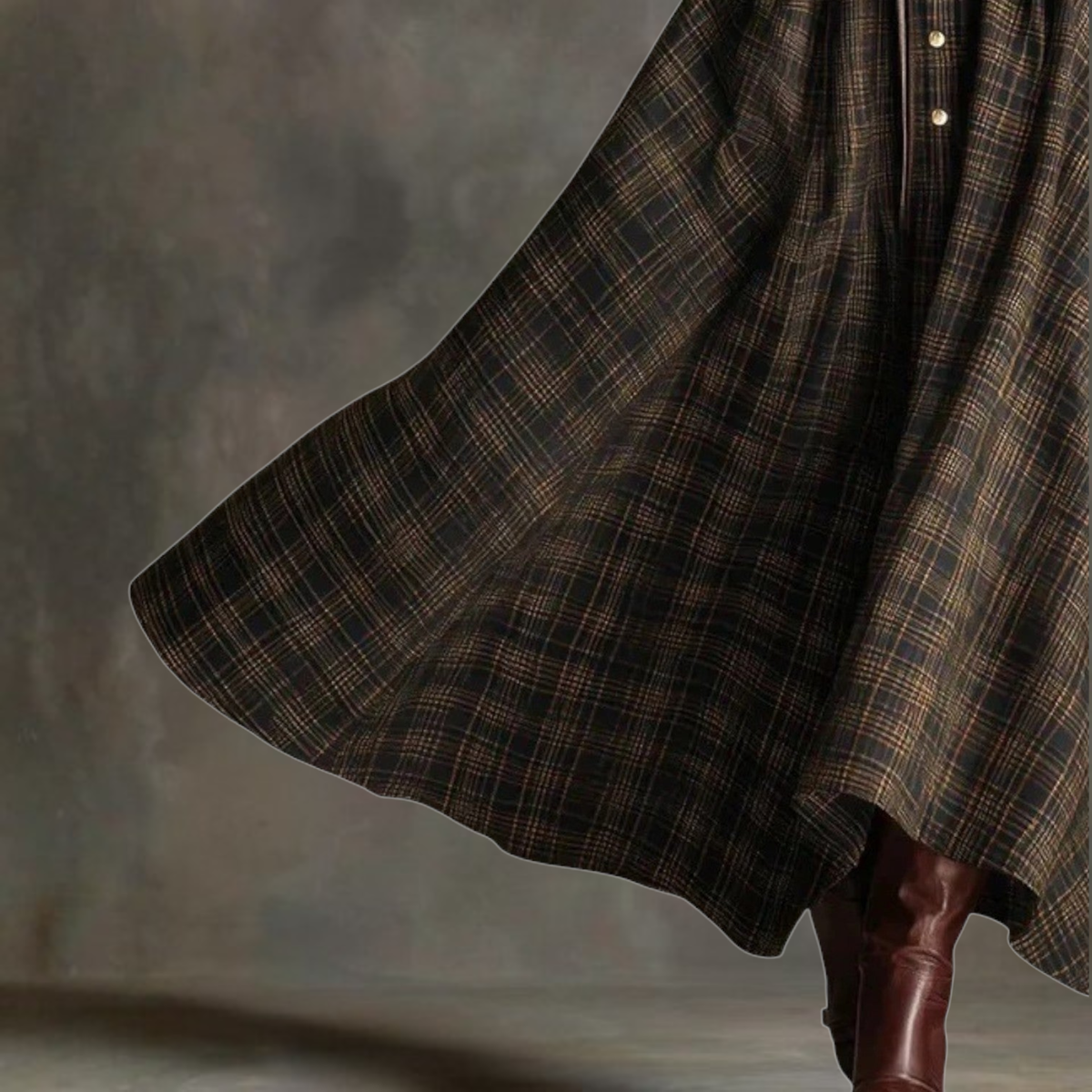 Close-up of the flowing tartan skirt and button placket on the Sara dress