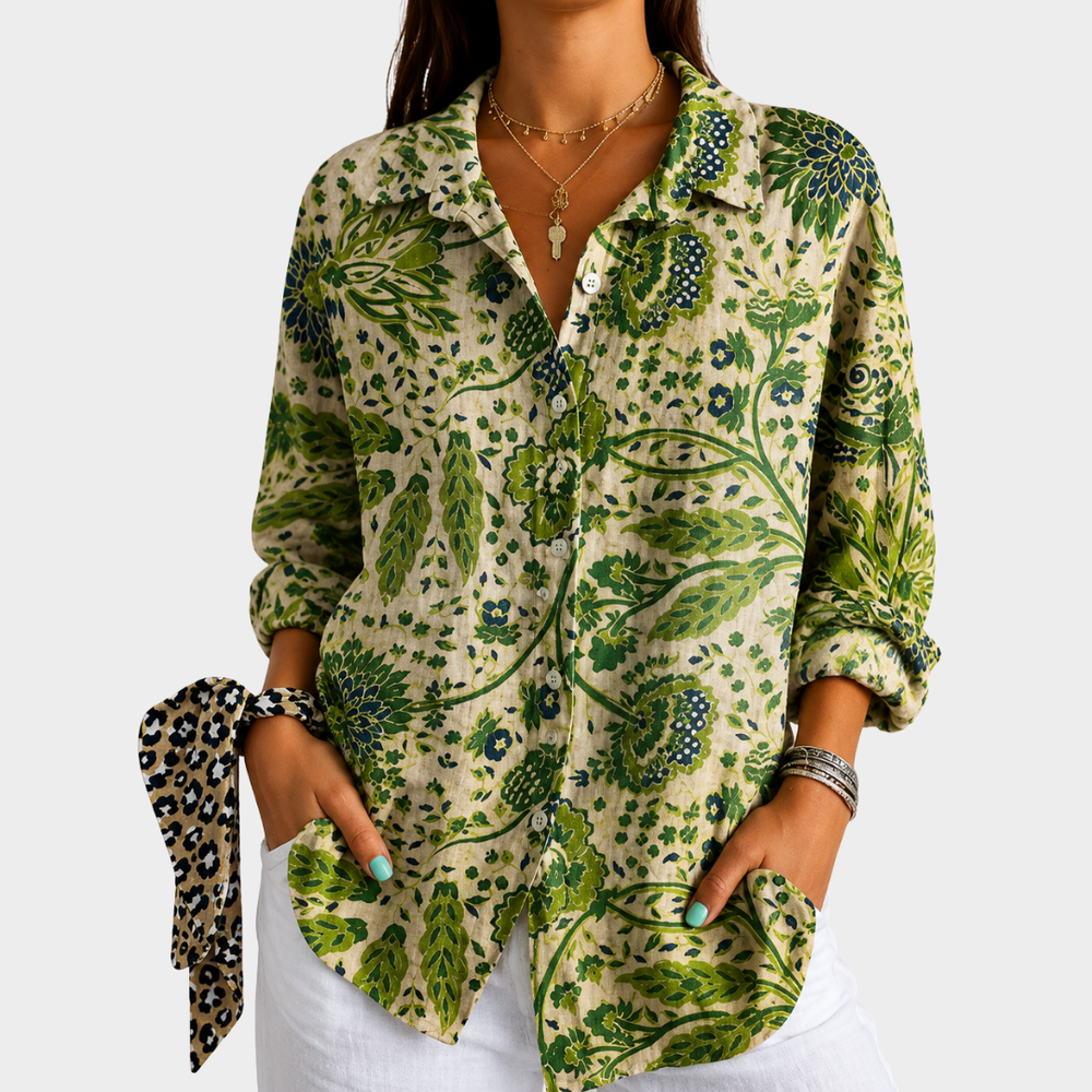 Green garden print blouse in green and cream, front view worn with white trousers
