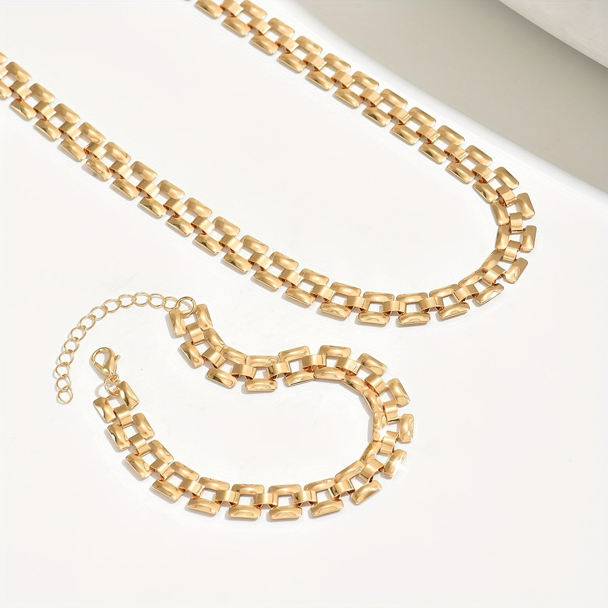 Gold panel-link necklace and bracelet set shown flat with clasp detail