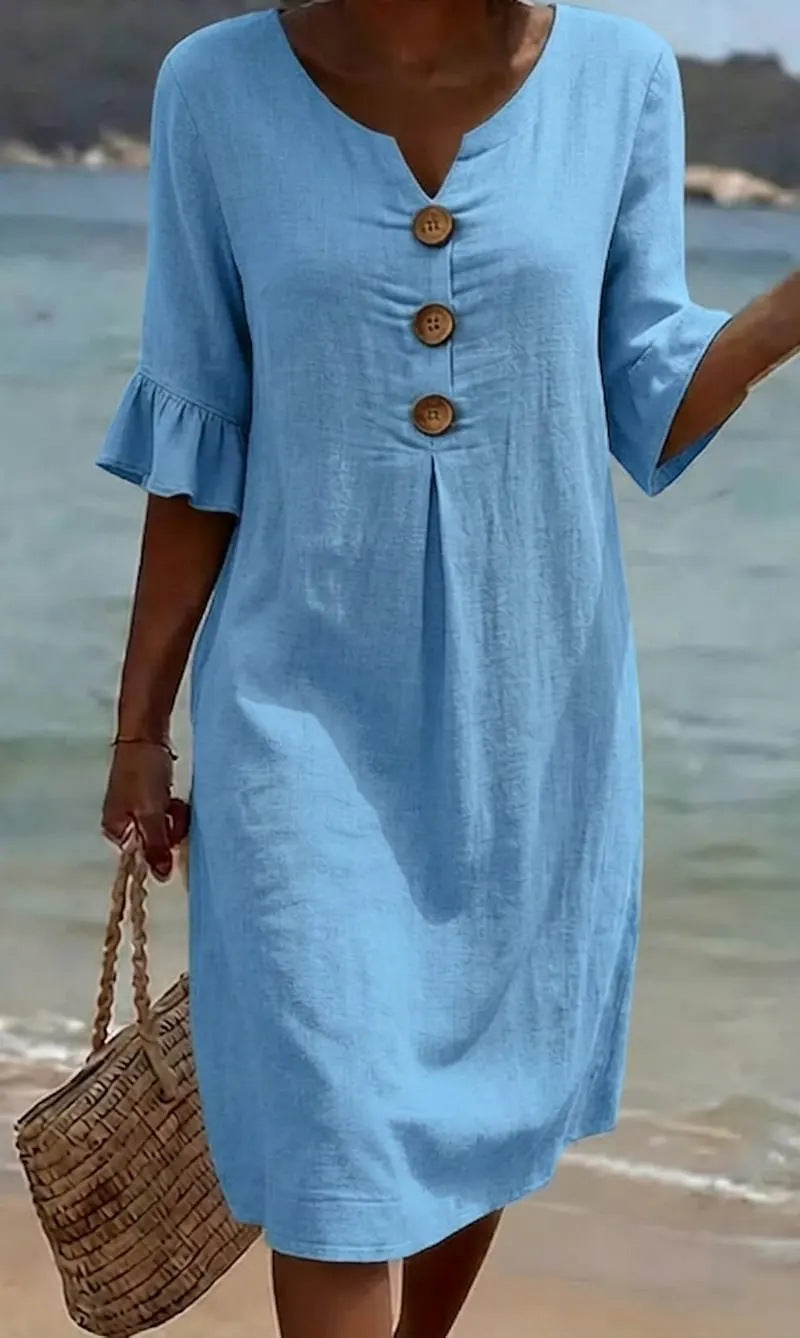 Blue casual button dress in light blue, front view worn on a beach