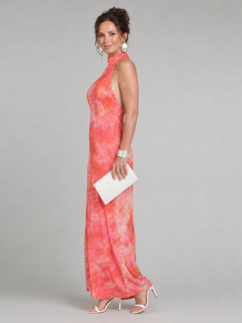 Coraline printed maxi dress in coral pink, side view with clutch