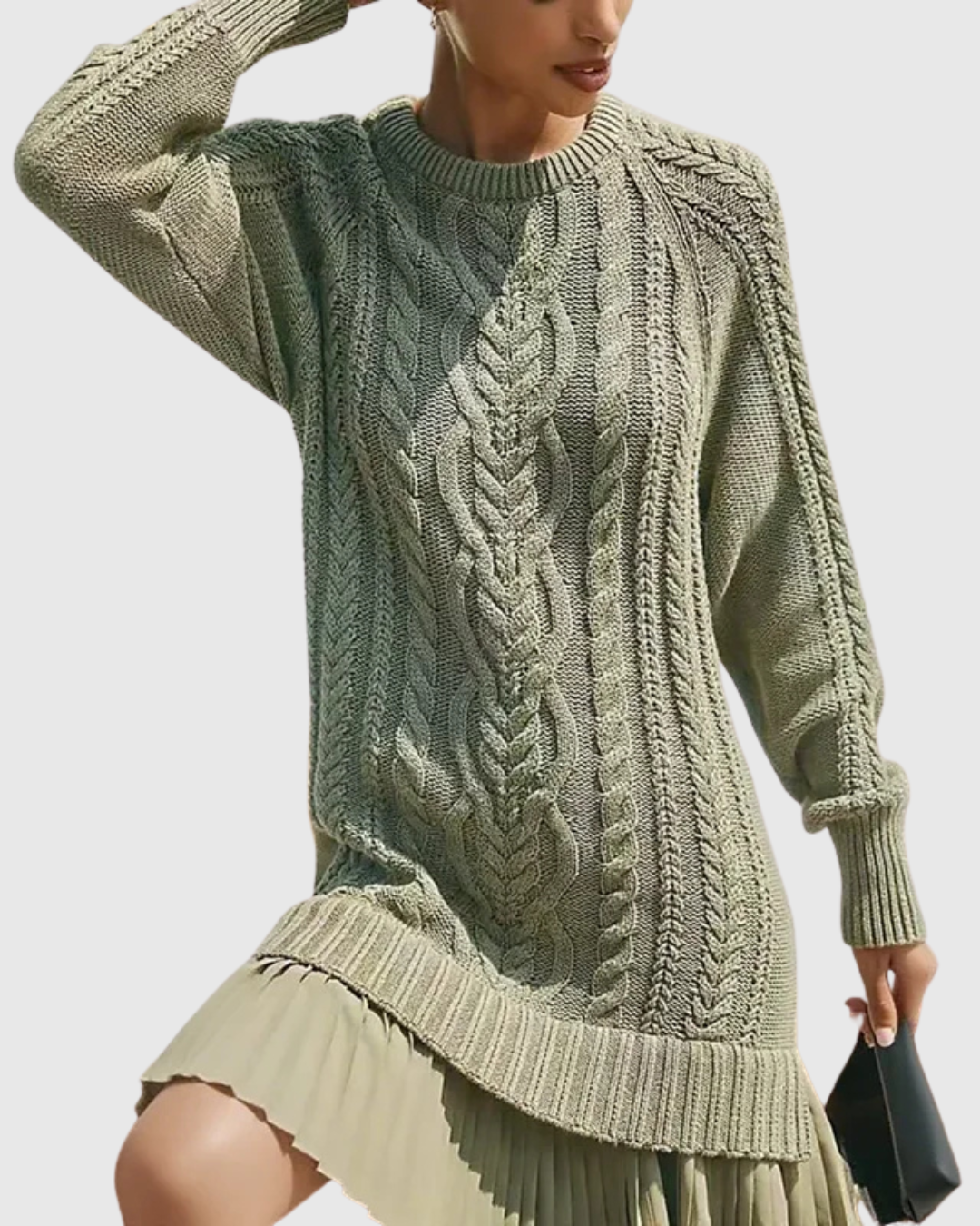 Eira sweater dress in green, close view of cable knit and pleated hem