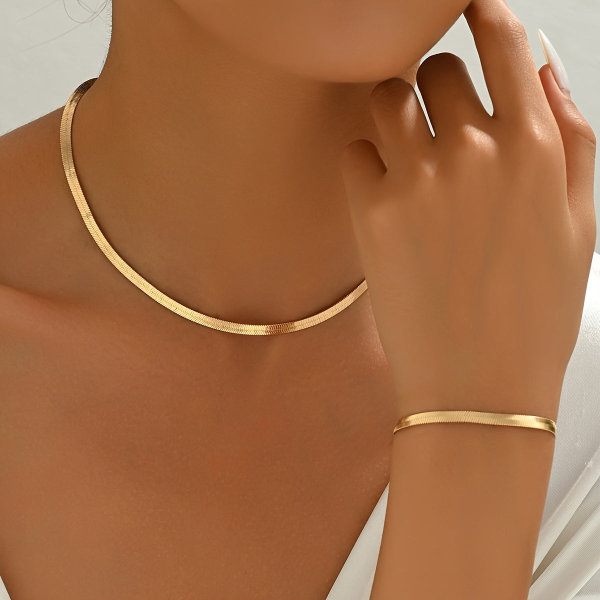 Gold flat chain collar necklace and matching bracelet worn on neck and wrist