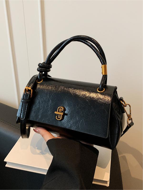 Emma small crossbody satchel in black, front view with gold twist lock