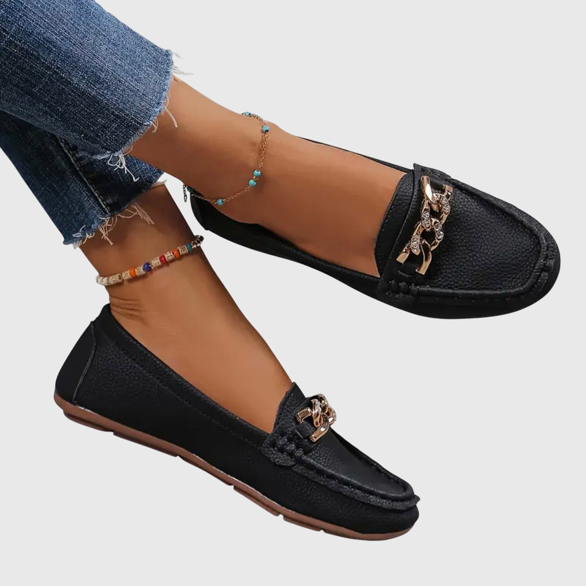 Madeleine chain-trim loafers in black, worn with jeans