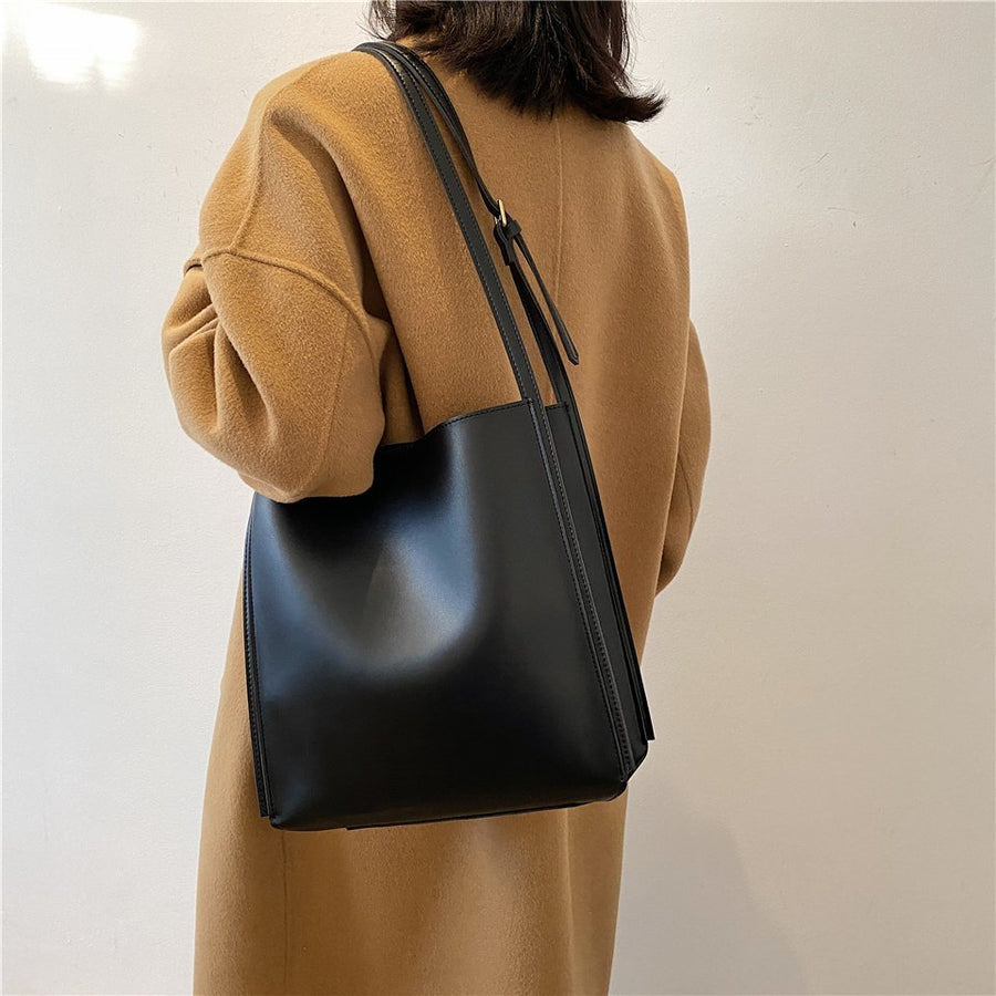 Viviana bag in black carried on the shoulder over a camel coat