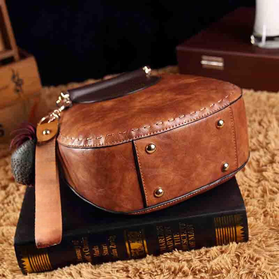 Naelle crossbody bag in caramel, side view showing stitching and studs