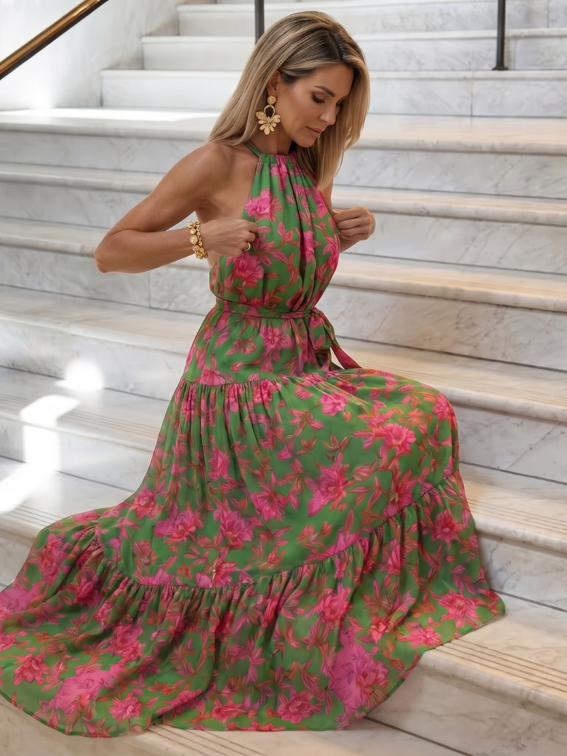Rowen floral halter dress worn on marble steps, tiered skirt spread out