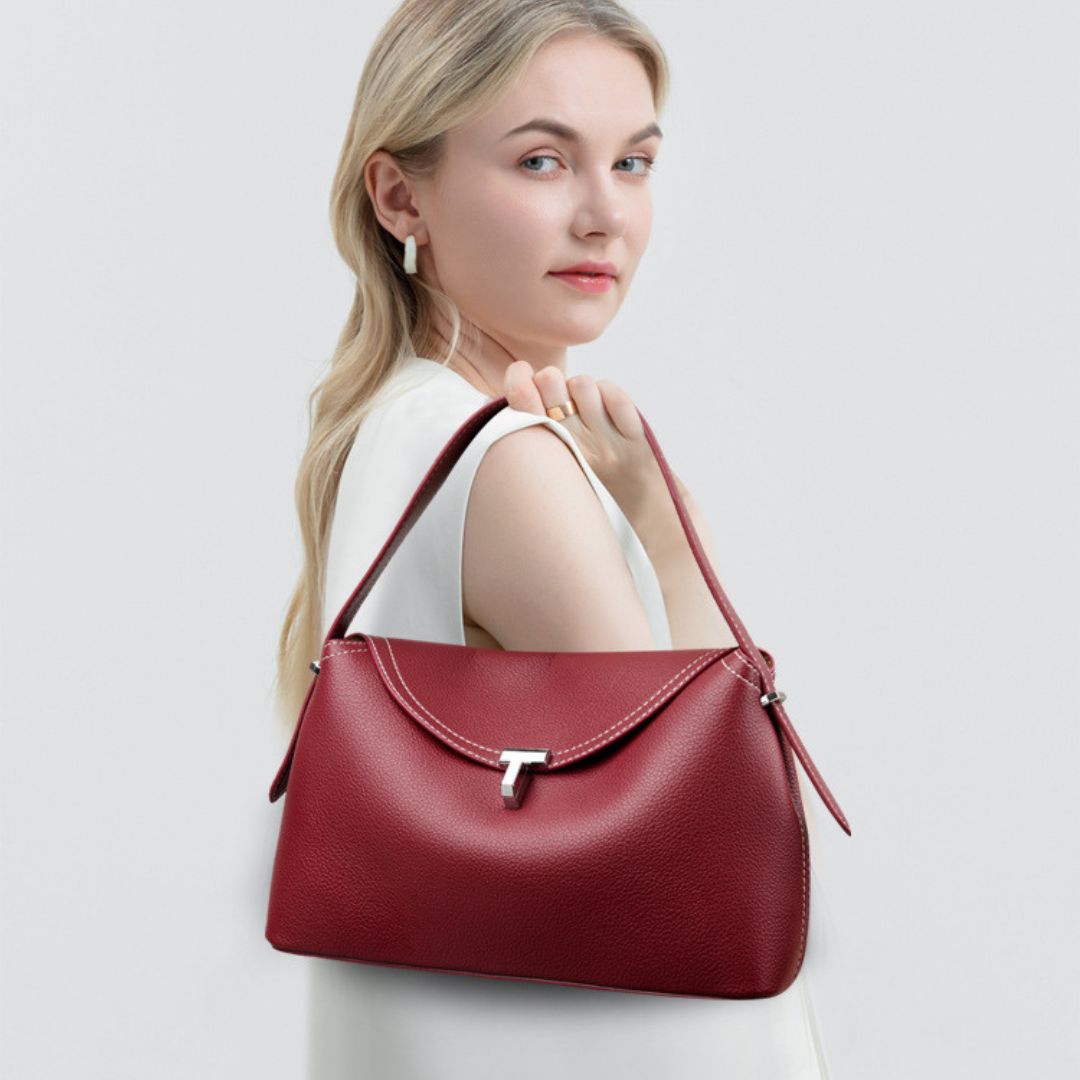 La Divine handbag in ruby red worn on the shoulder