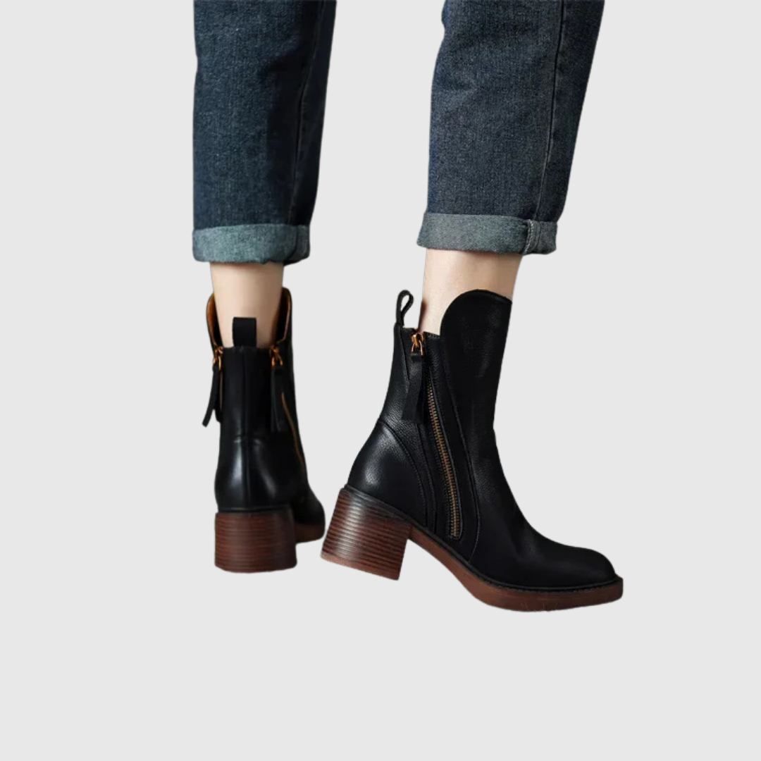 Streamlined ankle boots in black worn with turned-up jeans, back view