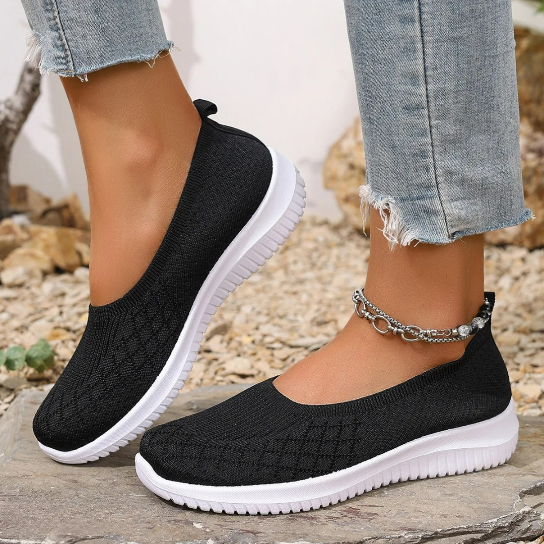 Estella slip-on shoes in black, worn with jeans, side view