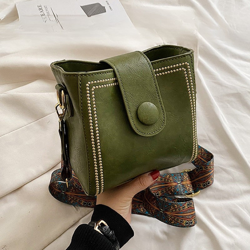 Ethel shoulder bag in green held in hand with boho patterned strap
