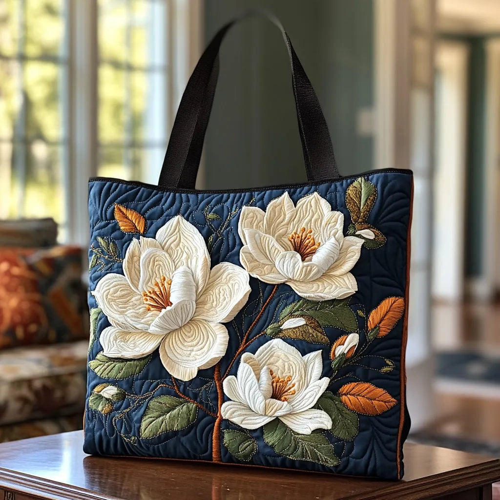 Handcrafted magnolia tote bag in navy with cream flowers, front view on a table