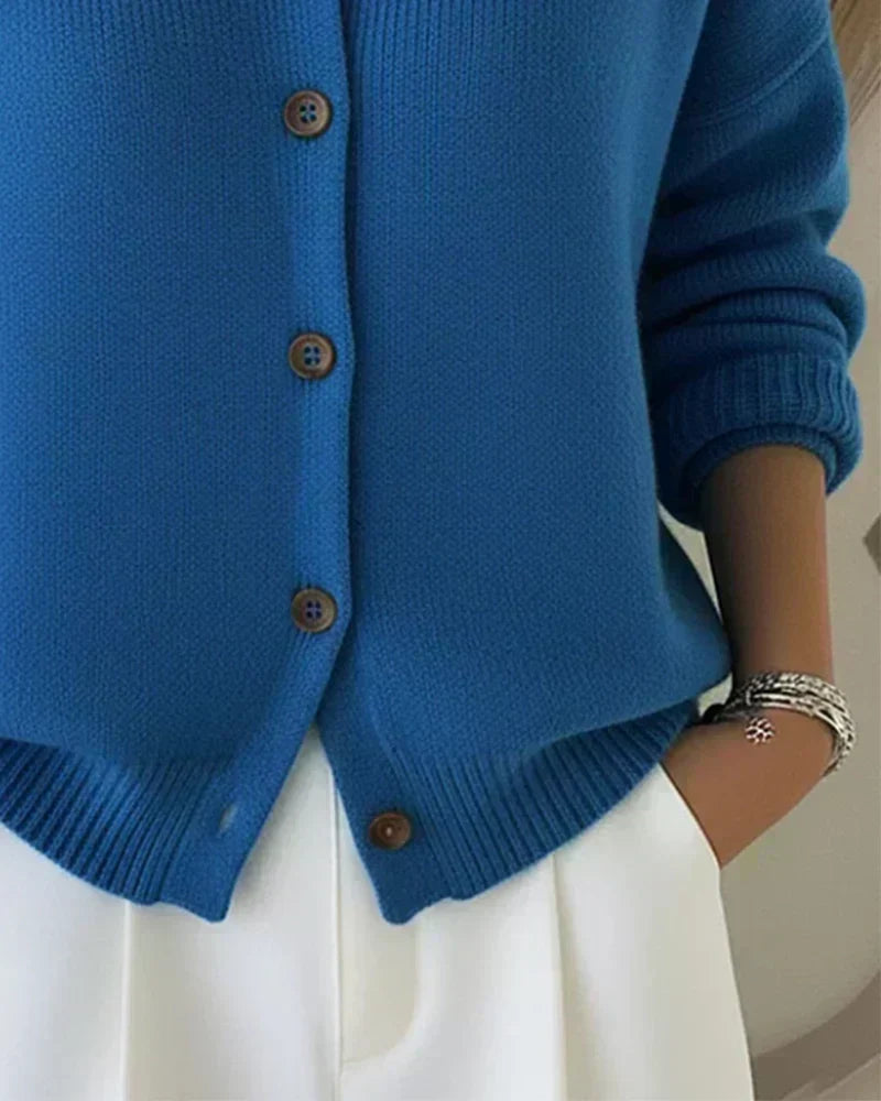 Vega cardigan in blue, close-up of wood-tone buttons and ribbed hem