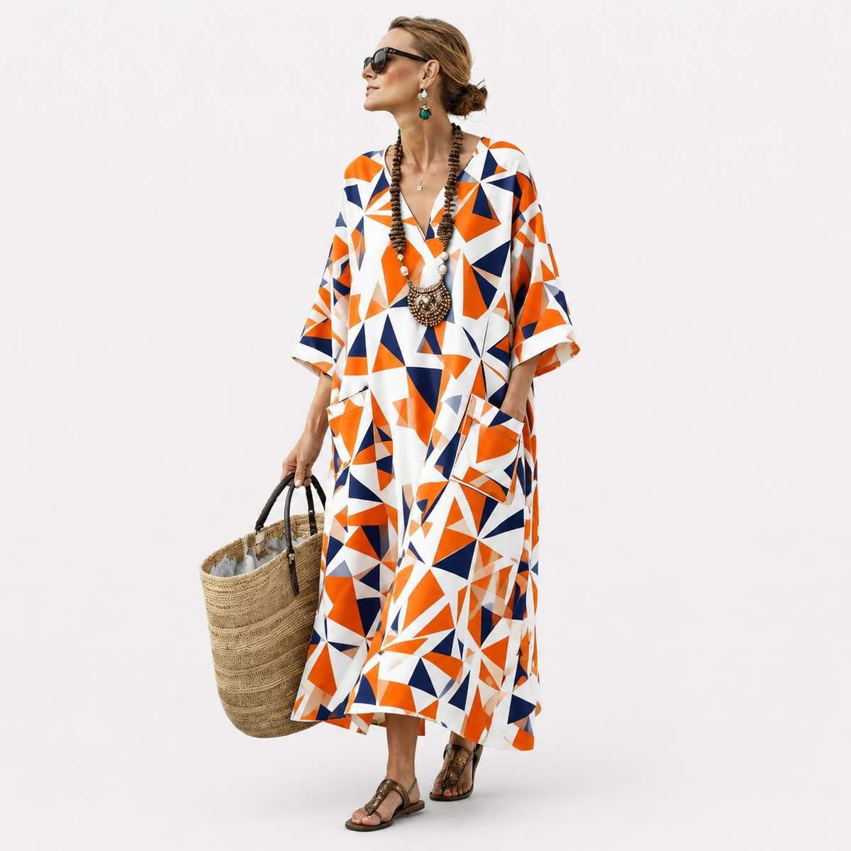 Long kaftan in orange and navy geometric print, full-length front view with straw basket bag