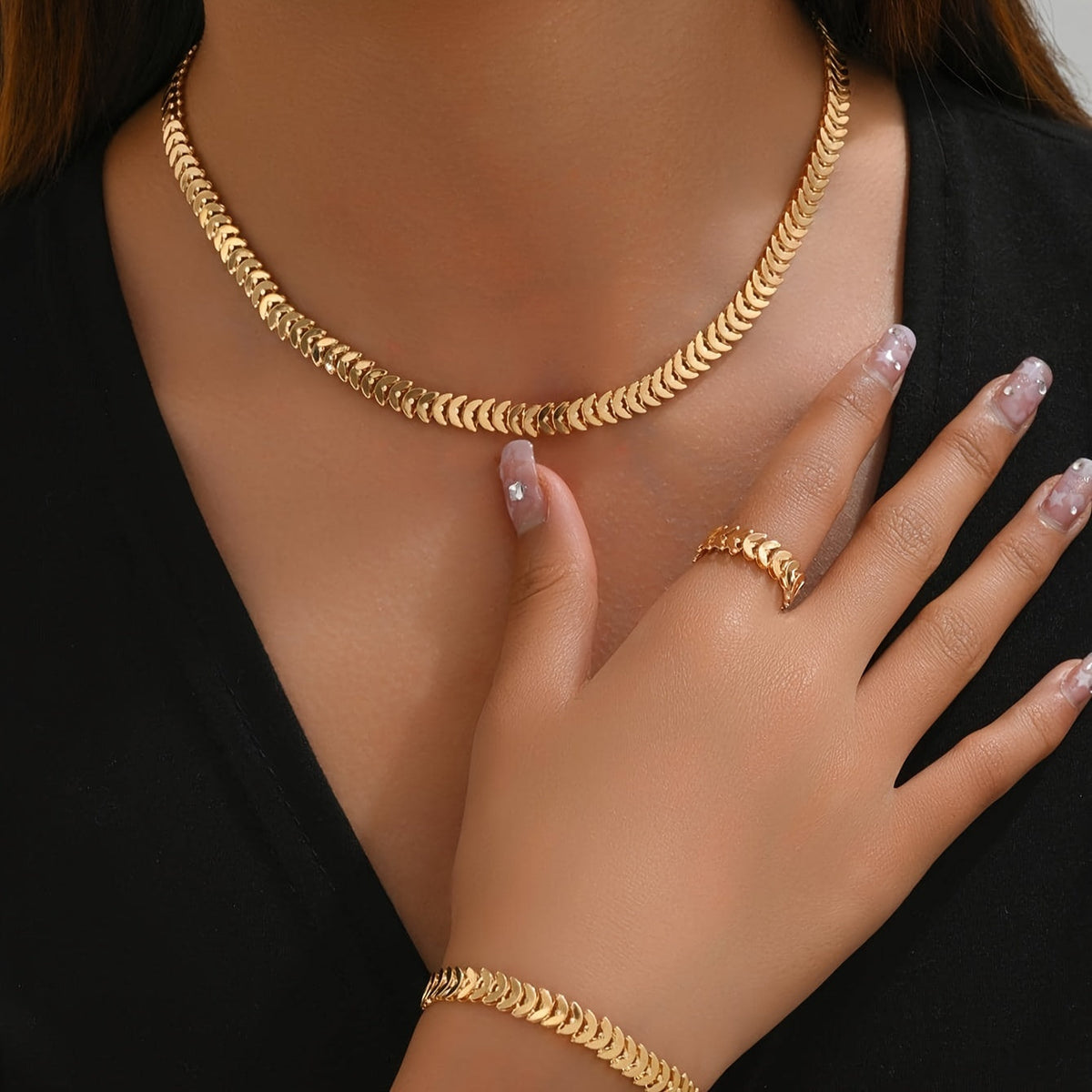 Model wearing gold minimalist necklace, bracelet and ring set, close view