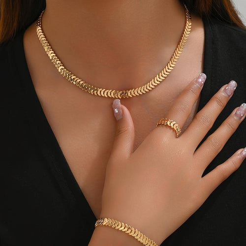 Model wearing gold minimalist necklace, bracelet and ring set, close view