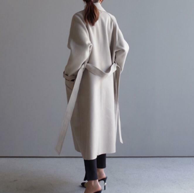 Cerys long trench coat in off-white, back view with belt hanging loose