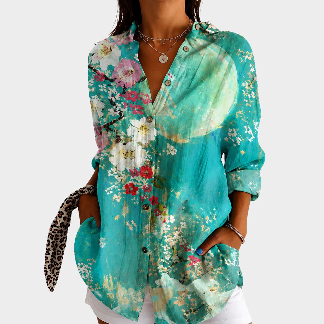 Cool blue floral blouse in turquoise with blossom print, front view worn with white shorts