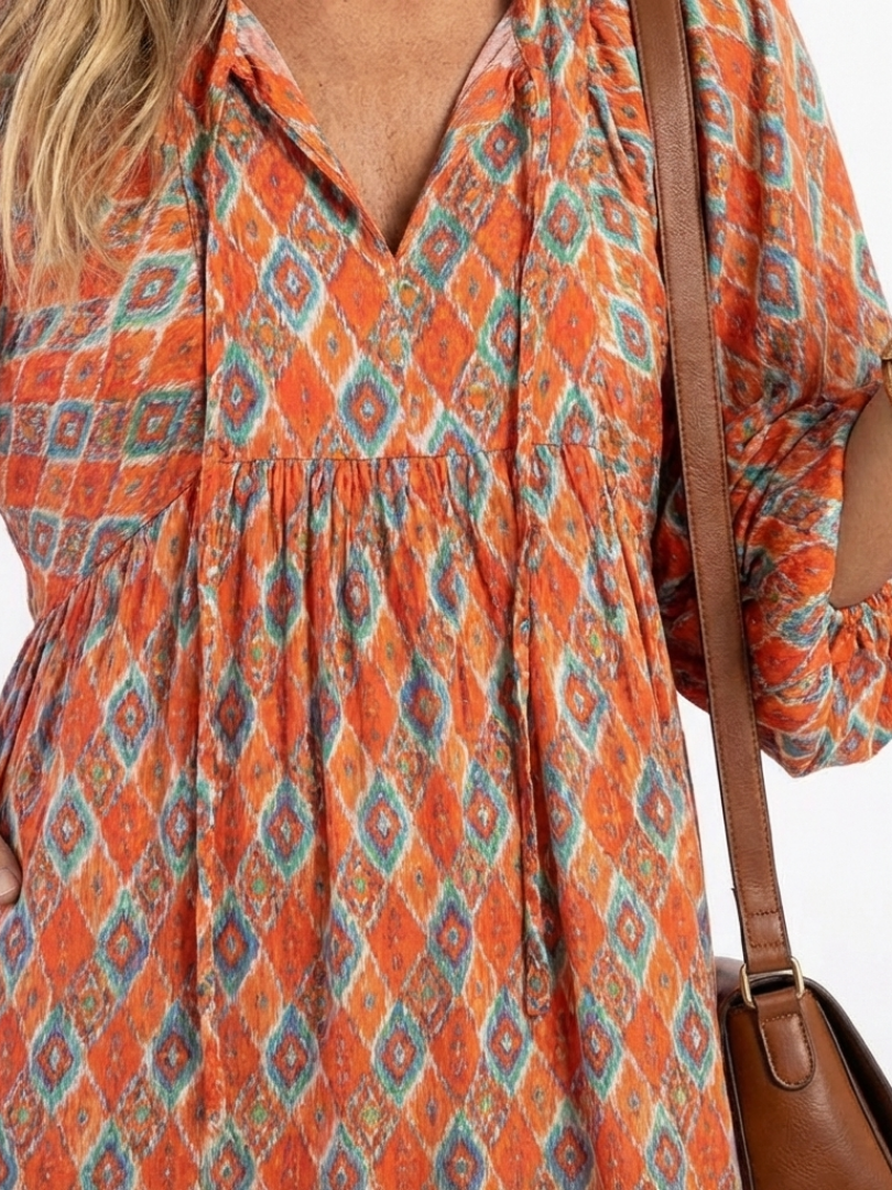 Close-up of Amara dress split V-neckline and geometric diamond print