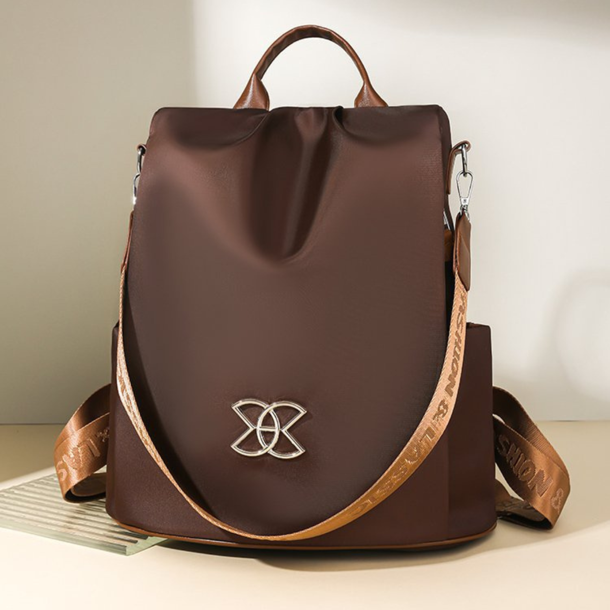 BeBold anti-theft backpack in brown with silver emblem, front view