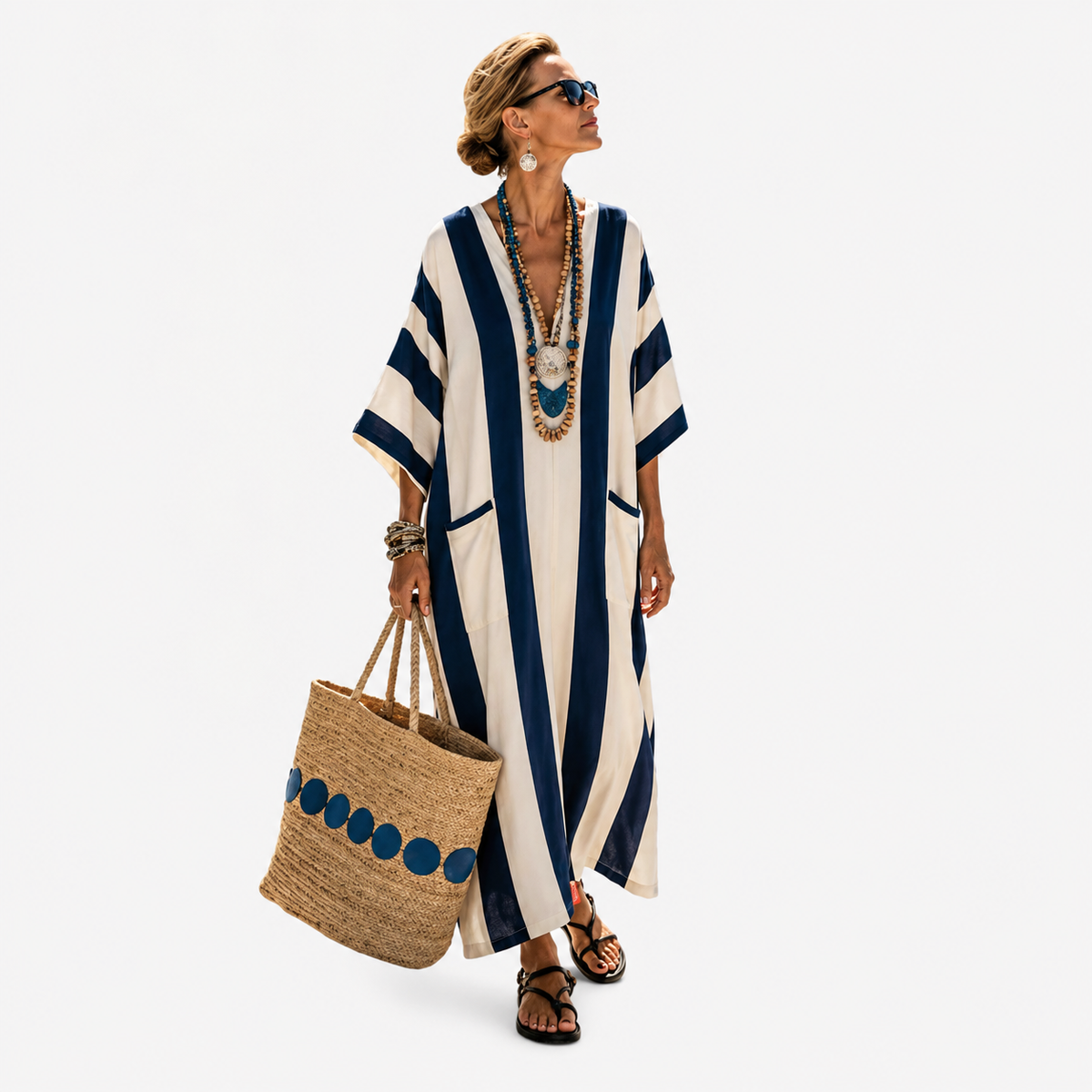 Long kaftan in dark blue and cream stripes, full-length front view with straw basket