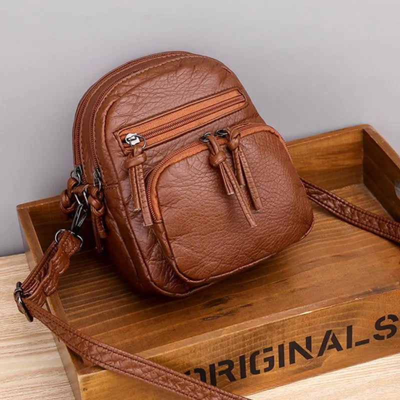 Amira chic satchel in brown, front view on a wooden tray