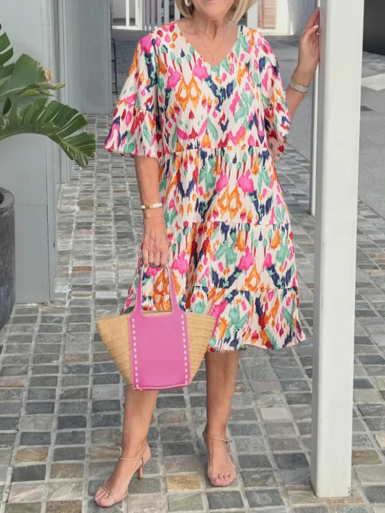 Isabella tunic dress in pink and green ikat print, front view with straw bag