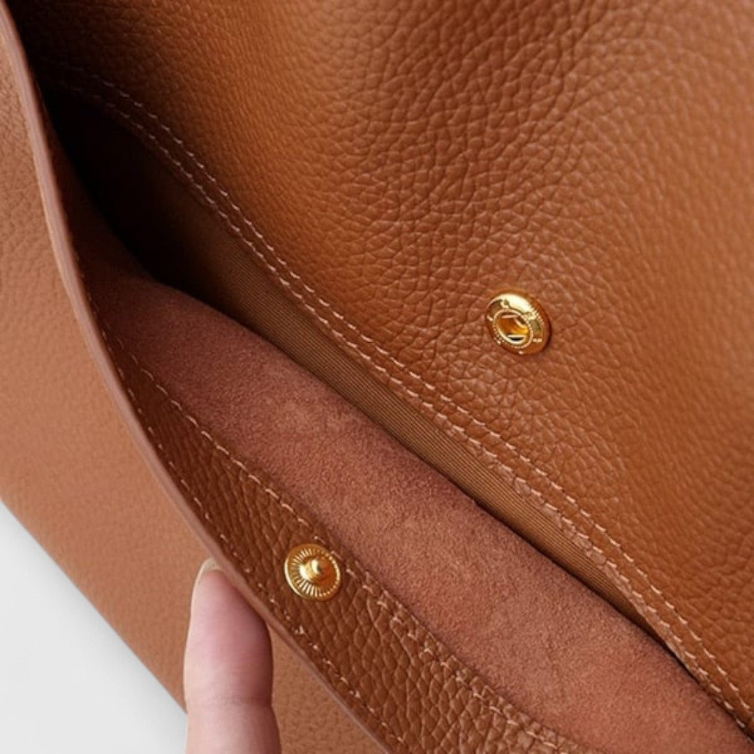 Close-up of brown tote magnetic press-stud closure and suede-look lining