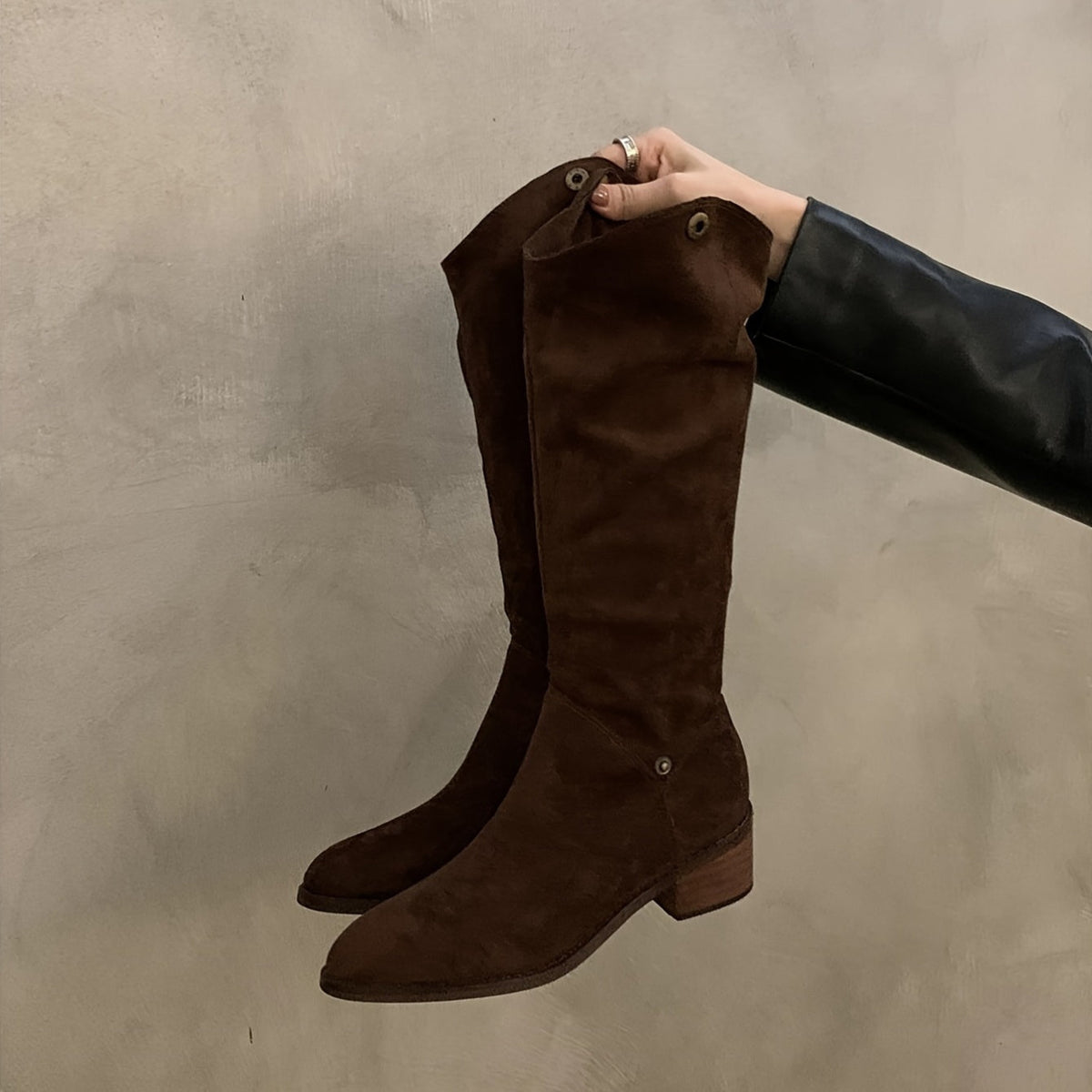 Evadne V-shape long boot in dark brown held in hand, full shaft side view