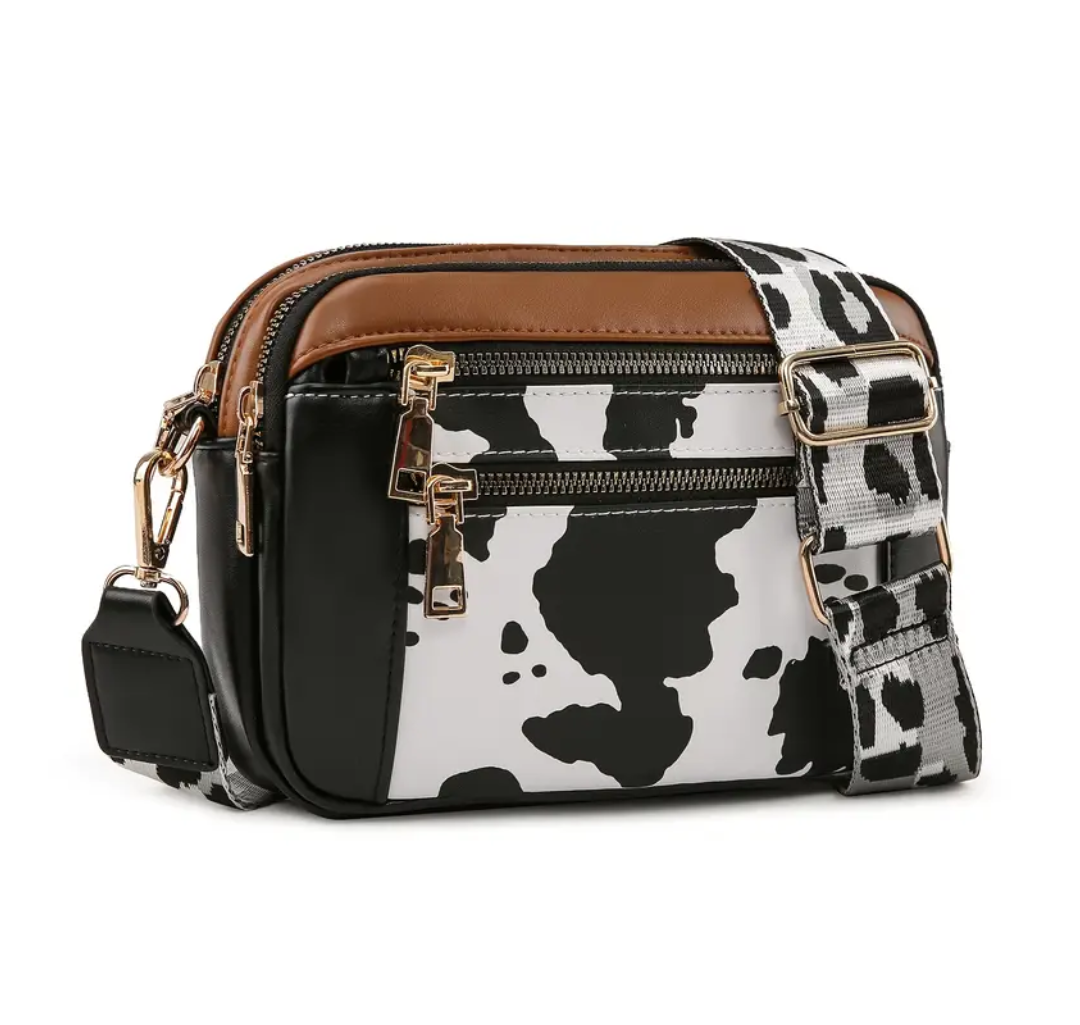 Strap crossbody bag in black cow print with animal print strap