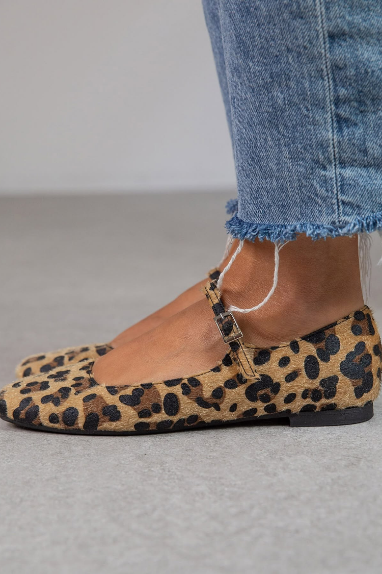 Leopard print ballet flats with adjustable ankle strap, side view worn with jeans