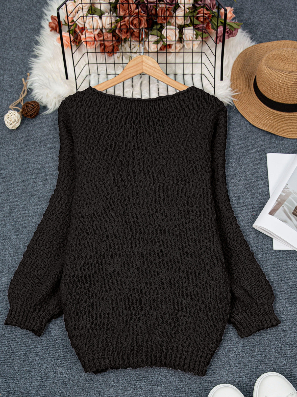 Noraya round neck sweater in black, flat lay on hanger