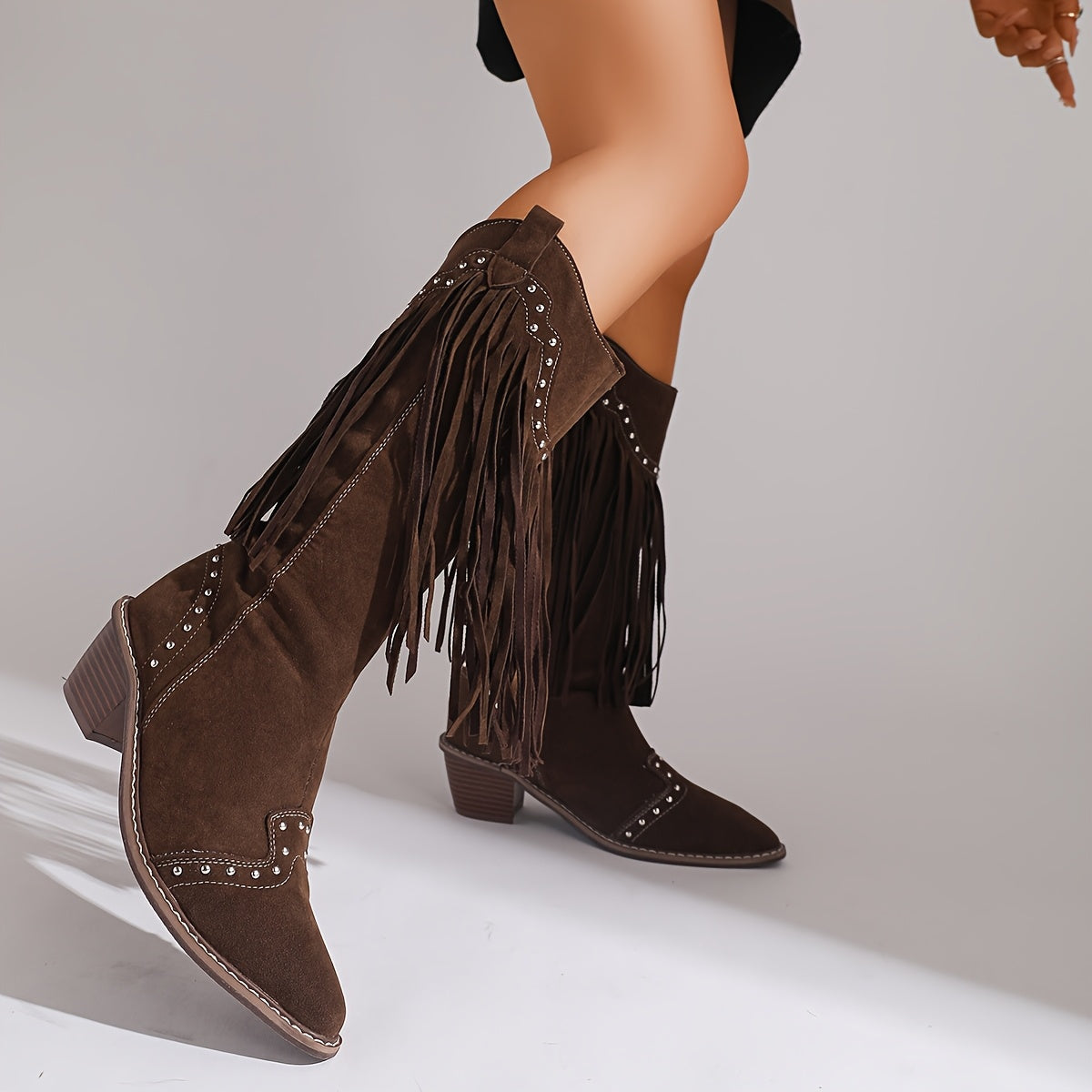 Marigold tassel-studded boots in dark brown, walking side view