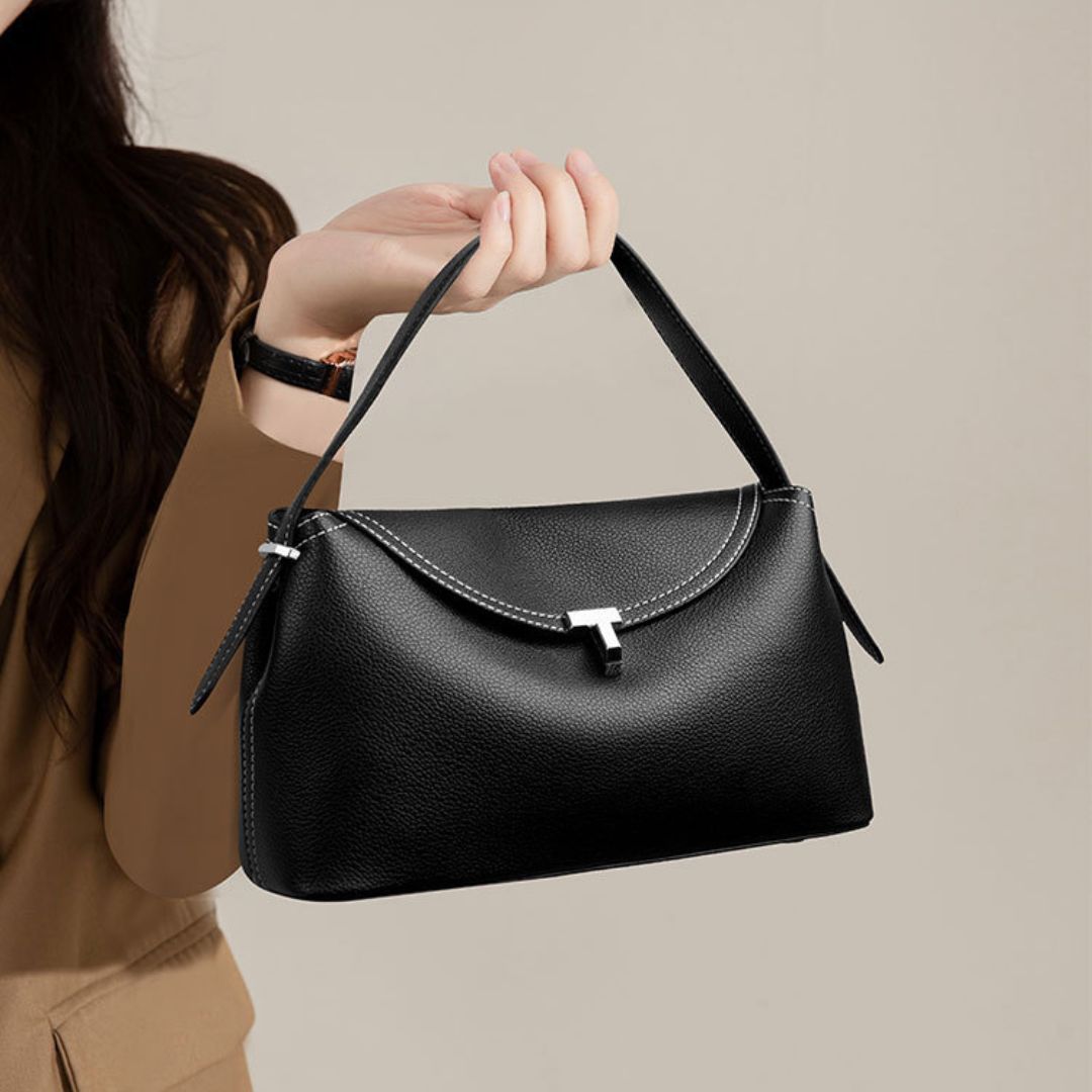 La Divine handbag in black held in the hand, close view