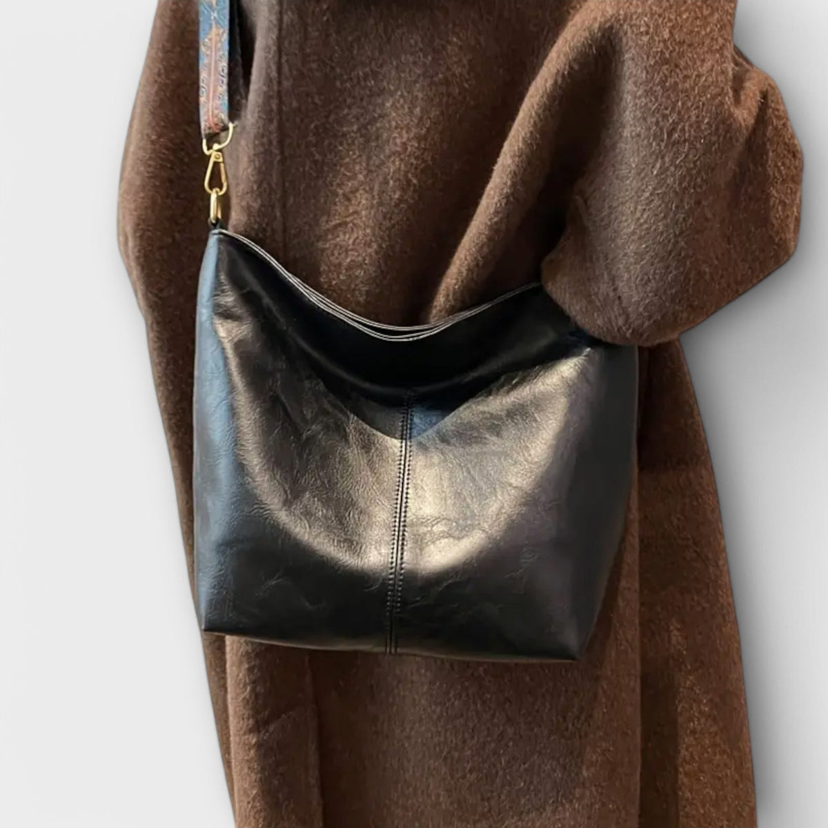 Agatha vintage shoulder bag in black worn crossbody over a coat