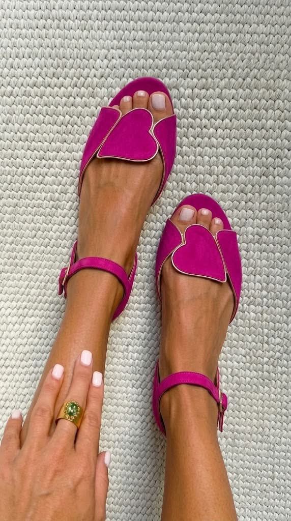 Fuchsia open-toe sandals with gold-edged heart panel, worn top view