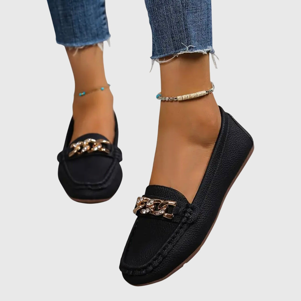 Madeleine chain-trim loafers in black, worn walking view