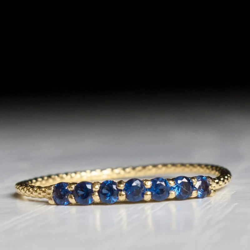 Gold beaded ring set with seven round stones, front view