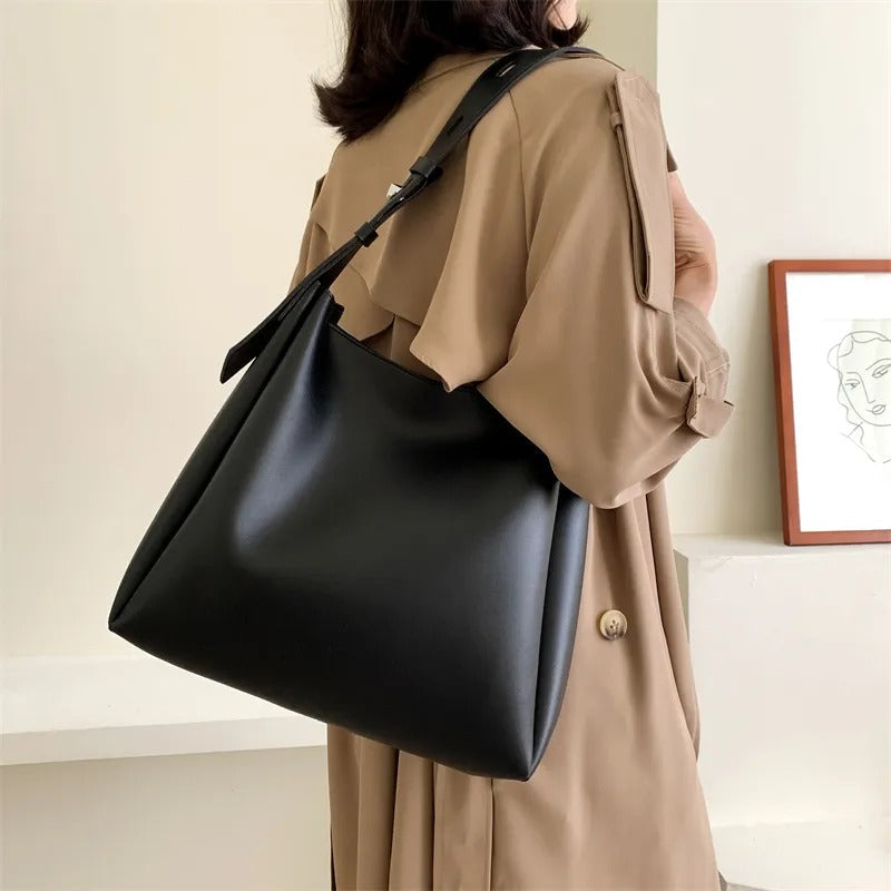 Delphine grand tote in black seen from behind on the shoulder