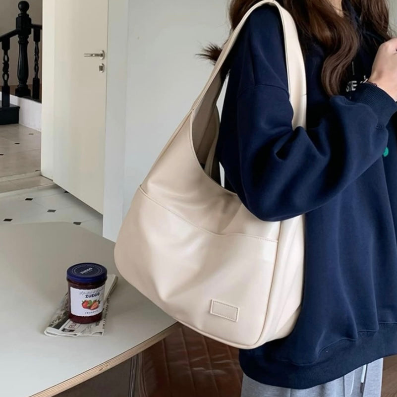 Fiora shoulder bag in cream, worn over the shoulder indoors