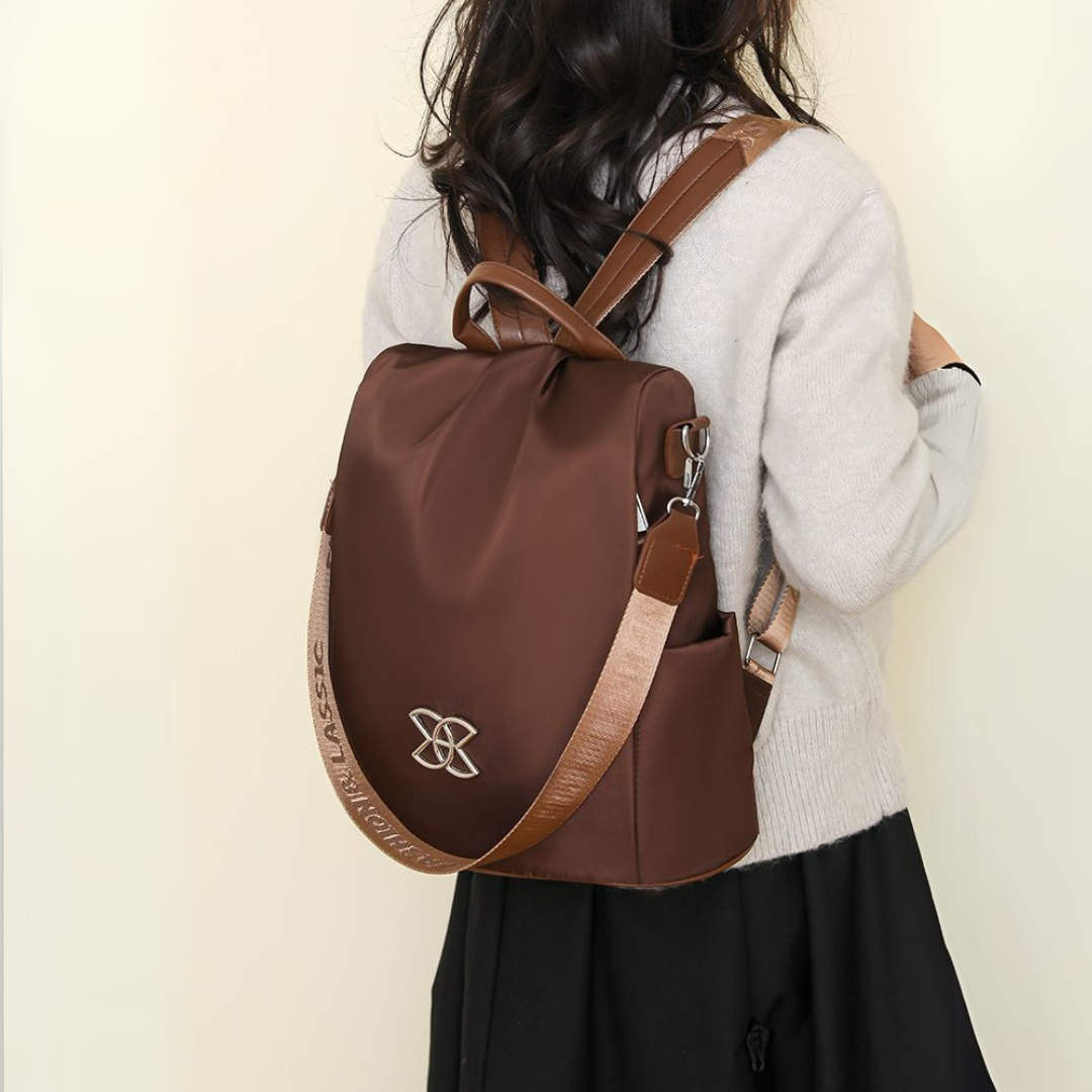 BeBold backpack in brown worn on the back with a cream cardigan