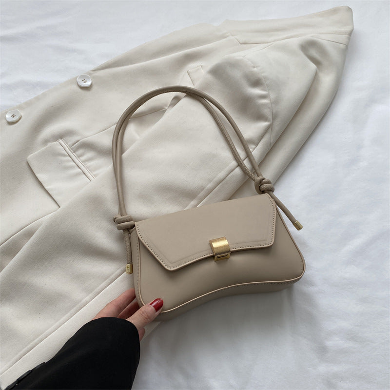 Cécile mini shoulder bag in beige, angled view on cream blazer