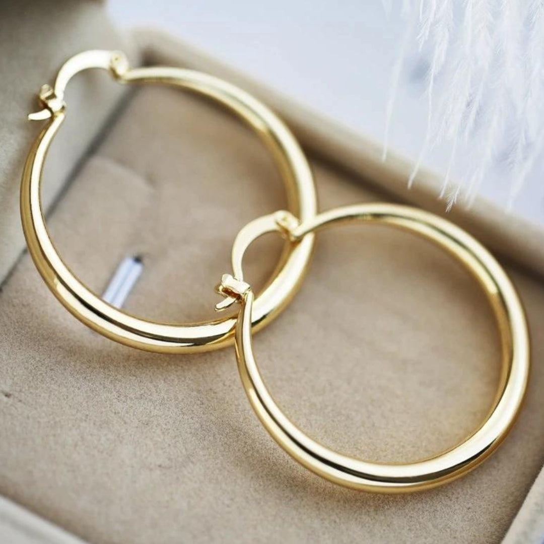 Timeless gold statement hoop earrings in a gift box, close-up angled view