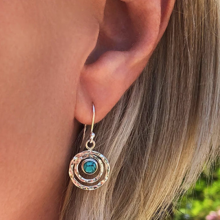 Boho gold Saturn drop earring with turquoise stone worn on the ear, side view
