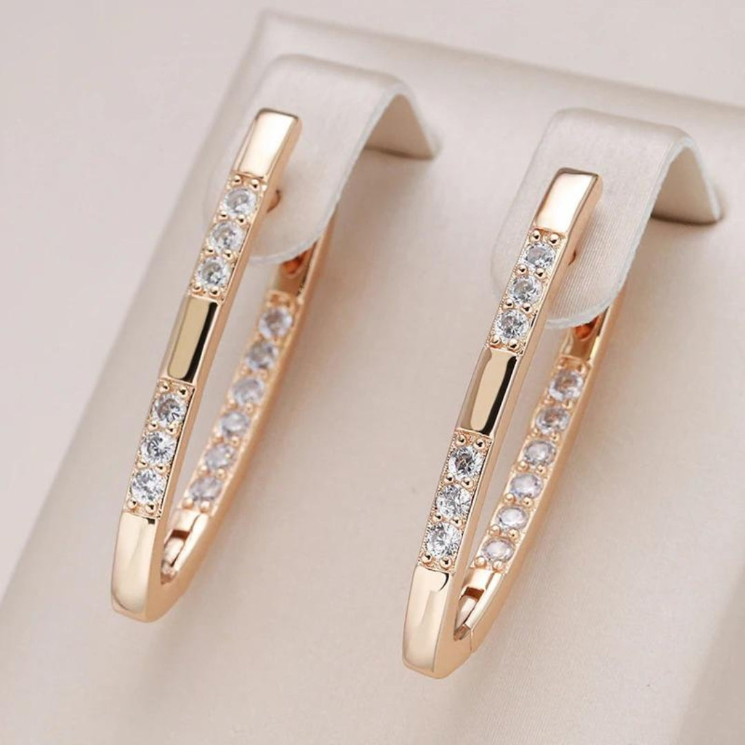 Gold zirconia hoop earrings with clear stone row, close-up view