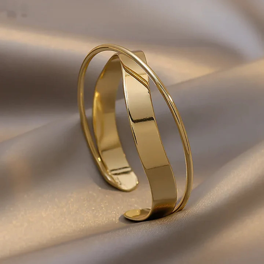 Classic polished gold bracelet, twisted open cuff shown at an angle