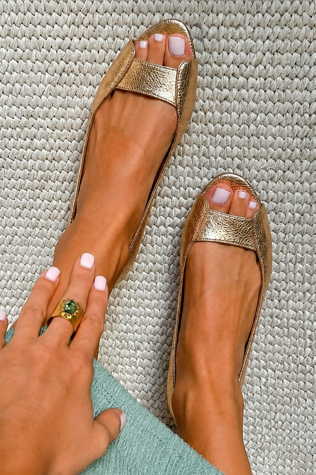 Adelina flat sandals in gold, close view on woven rug