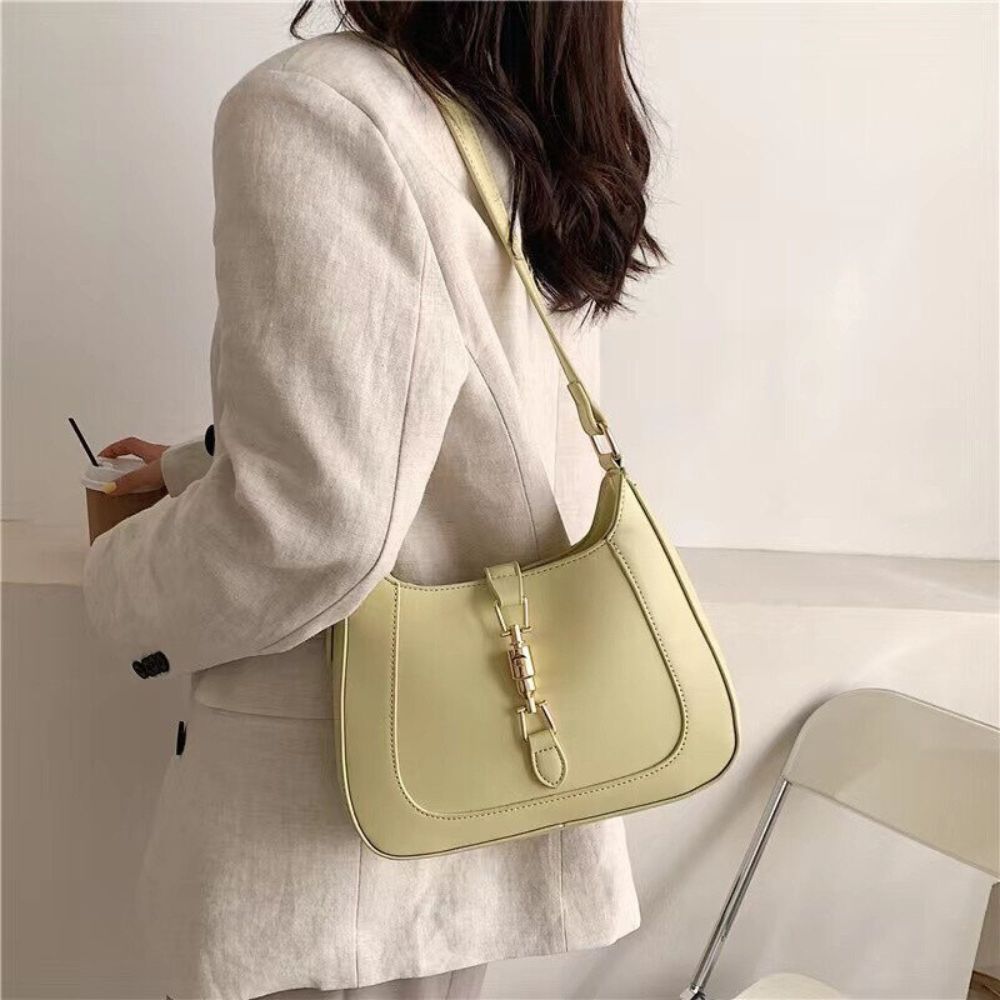 Classic curved shoulder bag in yellow worn over the shoulder